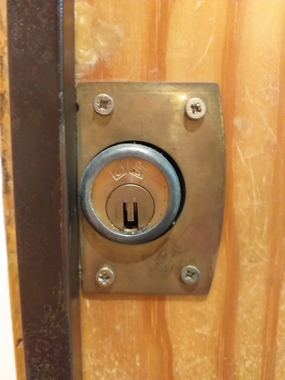Cilindro y placa de cerradura instalados en una puerta de madera